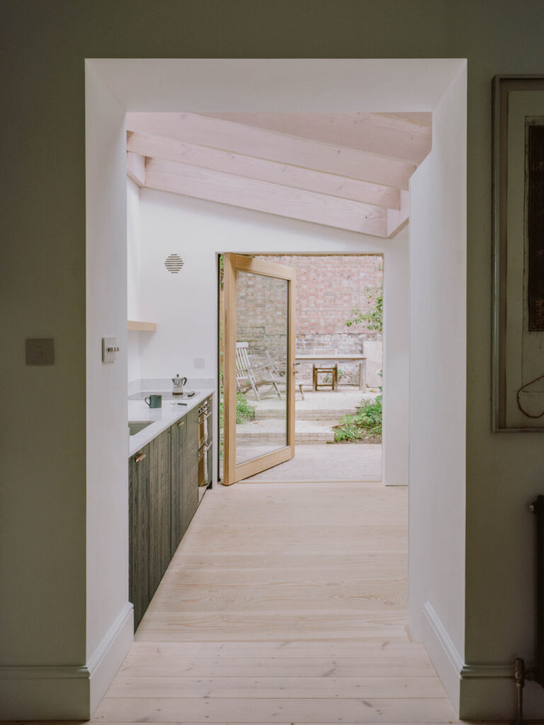 a timber pivot door opening out in a kitchen