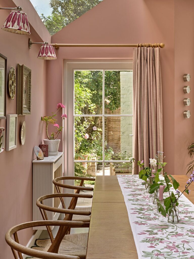 The pink dining room with a timber door