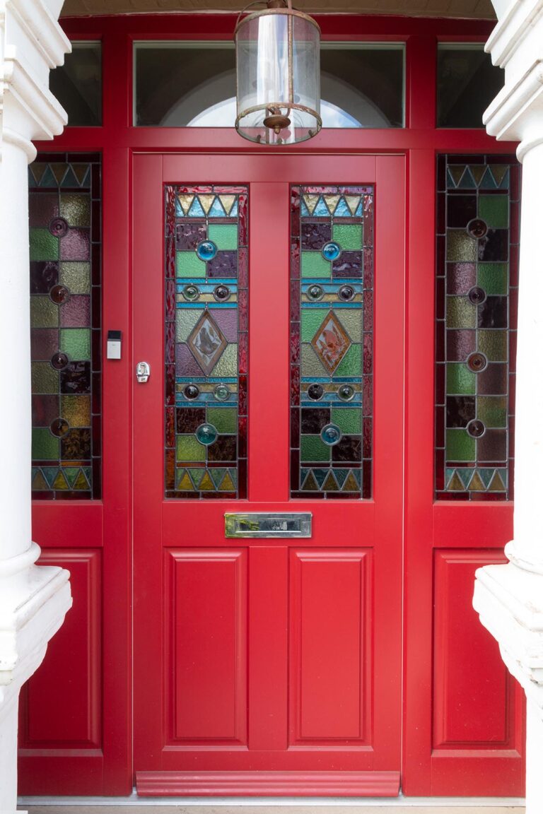 a red door with stained glass made from timber