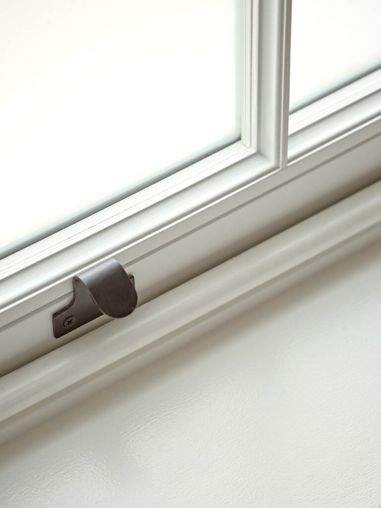 A sash window with a bronze sash lift