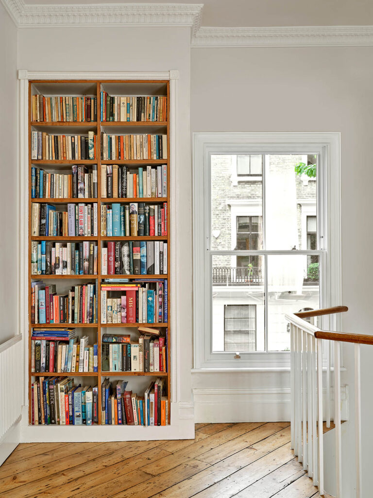 a sash window with a bookcase next to it