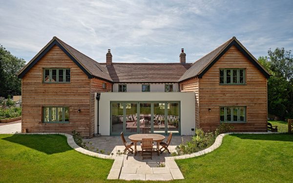 A wooden clad house with bifold doors and timber windows