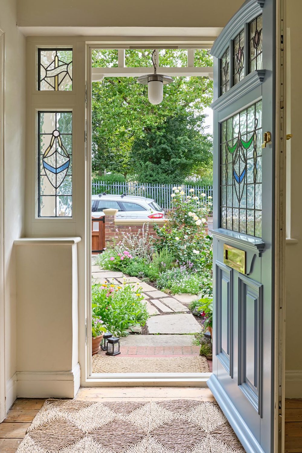 A timber entrance door with side light flags viewing a garden