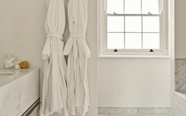 a timber sash window with some dressing gowns in a bathroom