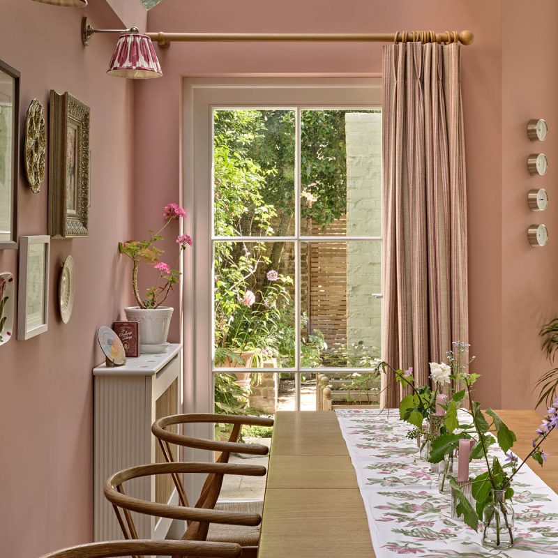 Pink dining room with timber door