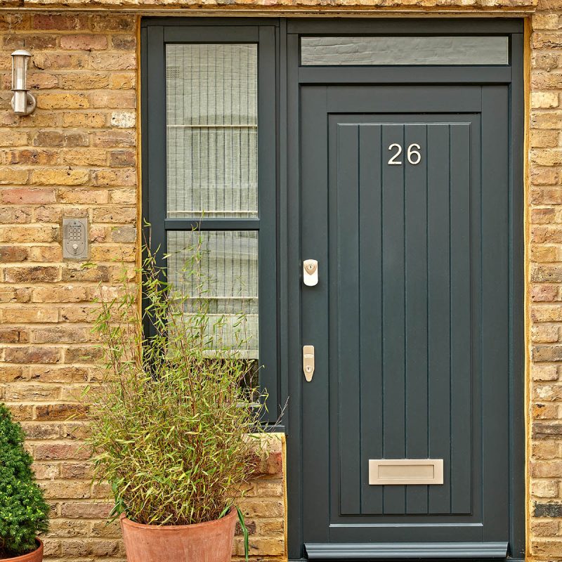 A black door in a mews house made from timber