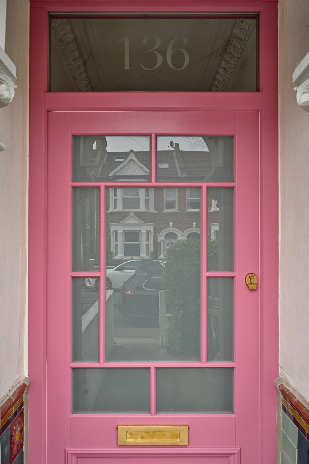 A pink front door with frosted glass.