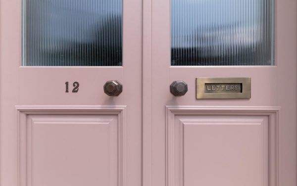 a pink door with red glass and antique brass fittings