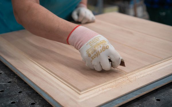 A person in the Sashed factory working on a timber door panel