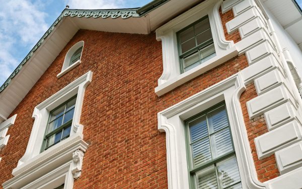 Timber sash windows in Surrey made by Sashed. The windows are flanked by red bricks