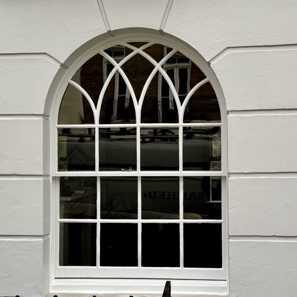 Timber sash windows restored by Sashed, with arched and curved glazing squares.